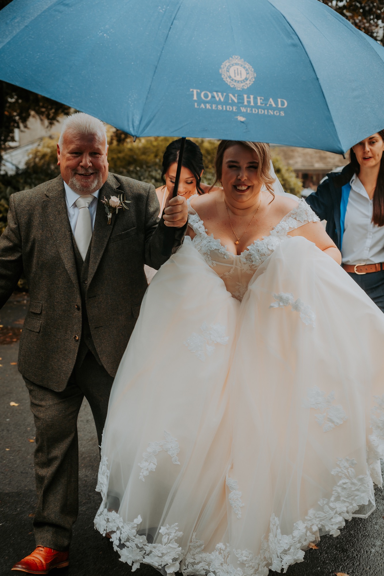 Father of the bride and bride under Town Head Estate Umbrella on a rainy wedding morning
