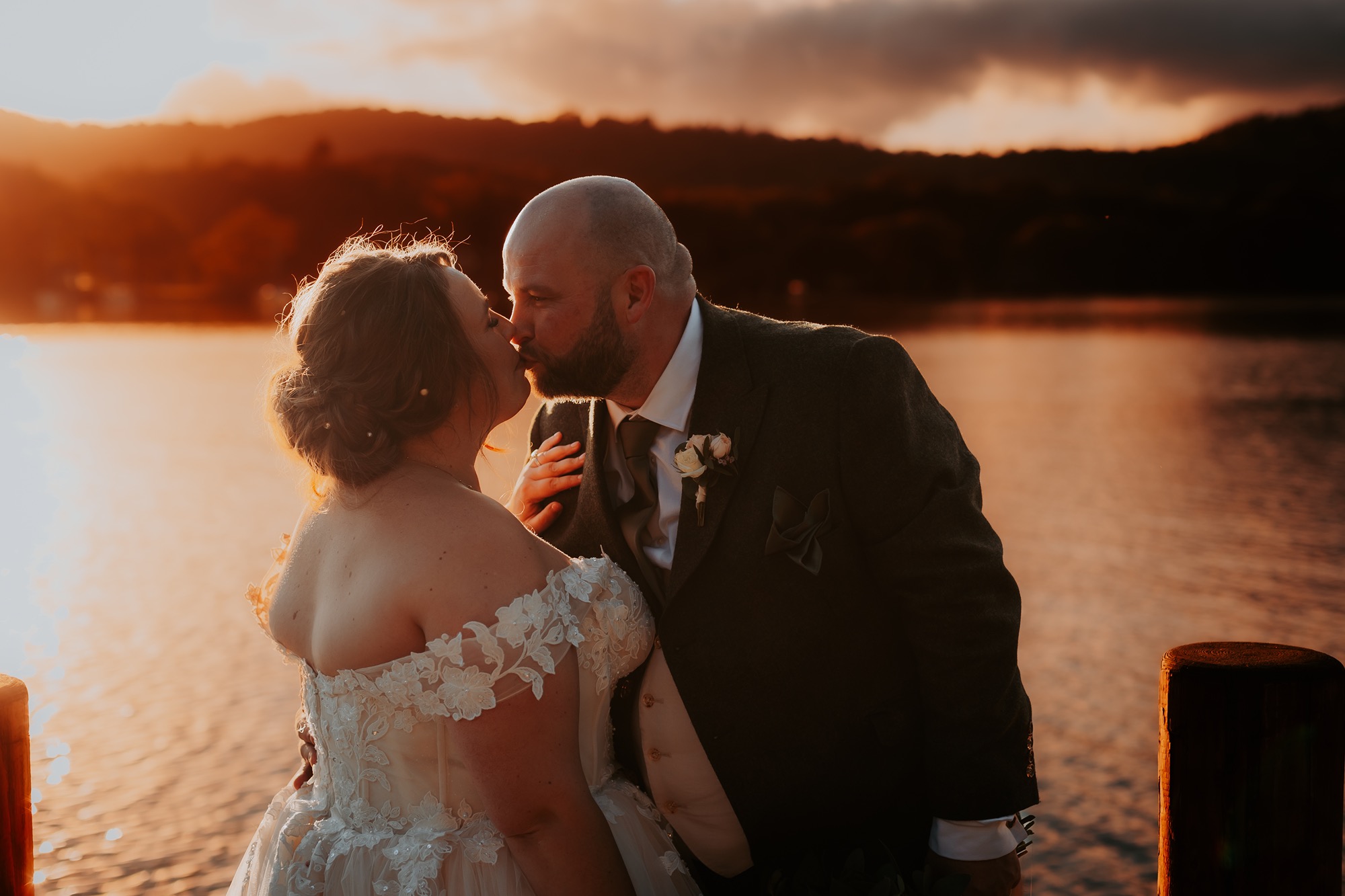 Newly-weds kiss on private jetty, Windermere, Lake District