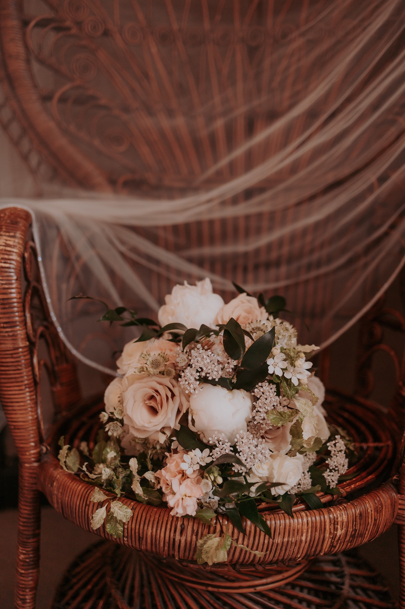 Wedding bouquet laid on wicker chair as bride gets ready at Falcon Manor, North Yorkshire wedding venue