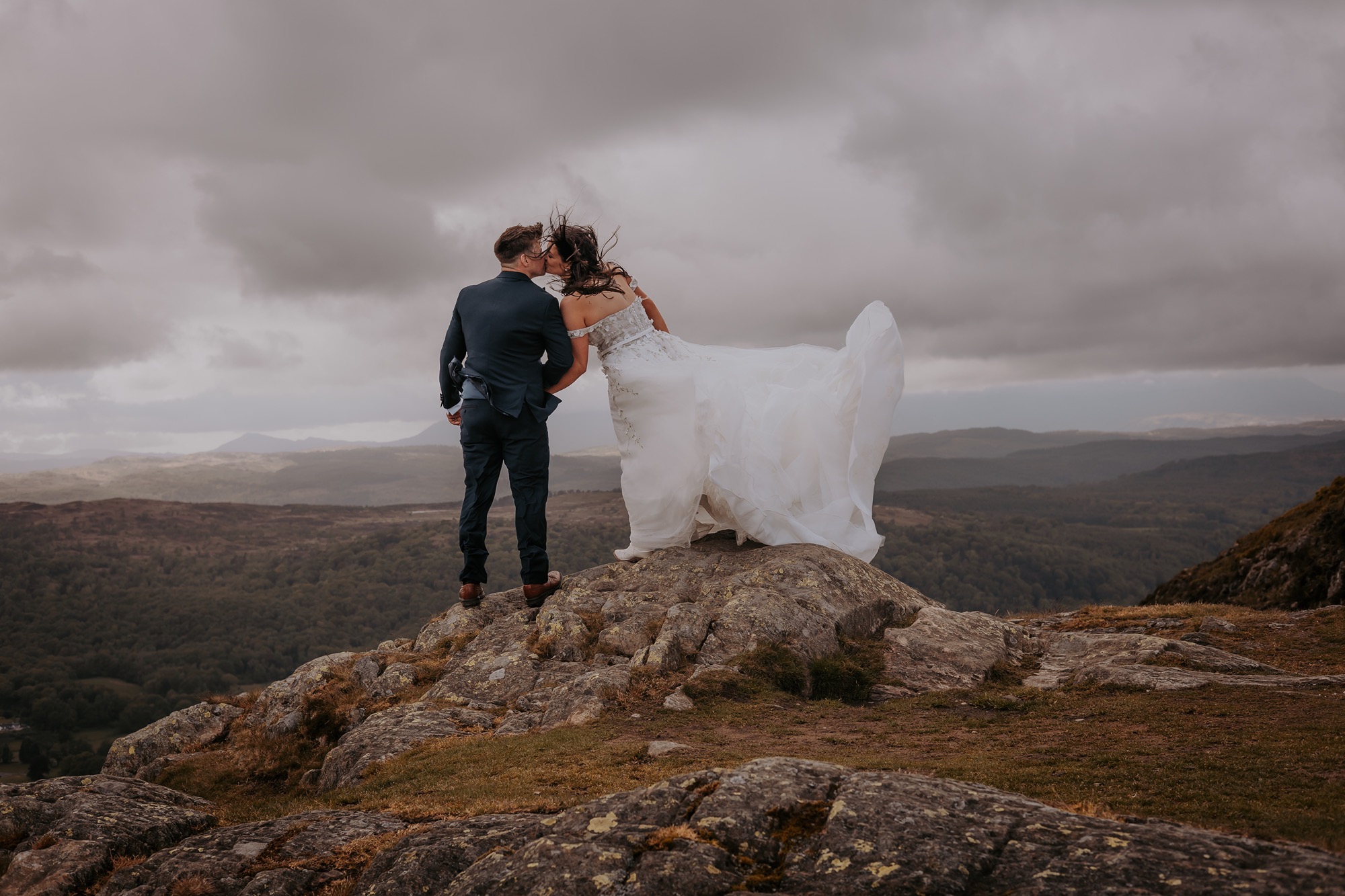Hiking couple climb Lake District mountain to celebrate wedding in Windermere. 