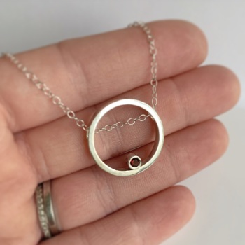 Silver circle necklace with garnet