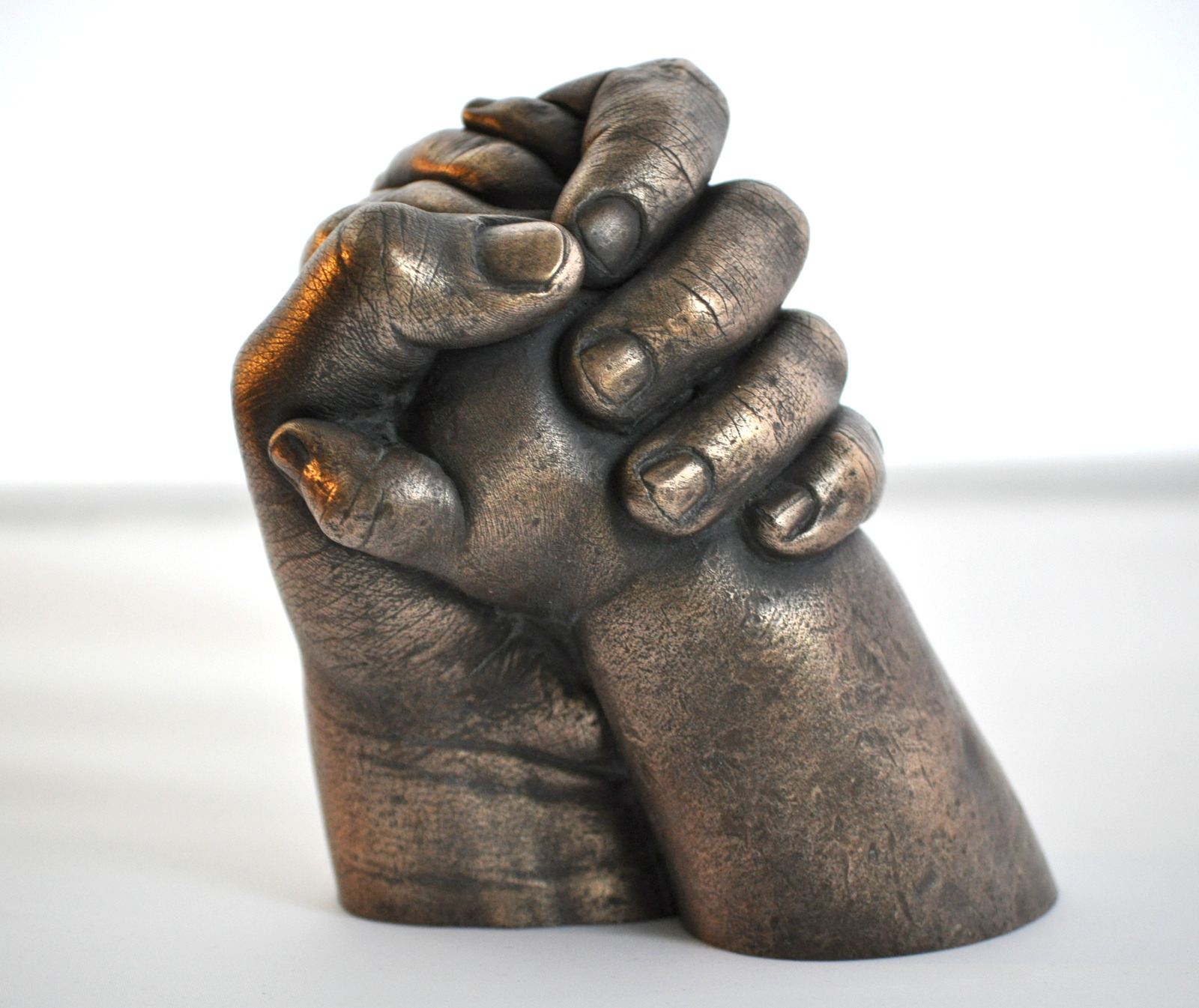 Sibling holding hands in bronze resin