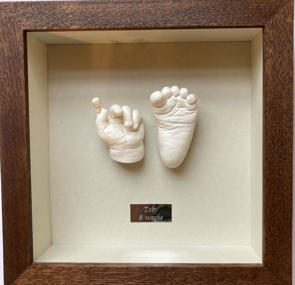 Plaster  baby hand and foot  framed in walnut oak