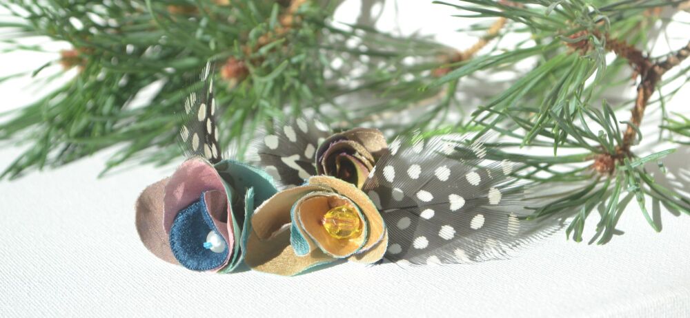 flower and feather decorations on a pine branch