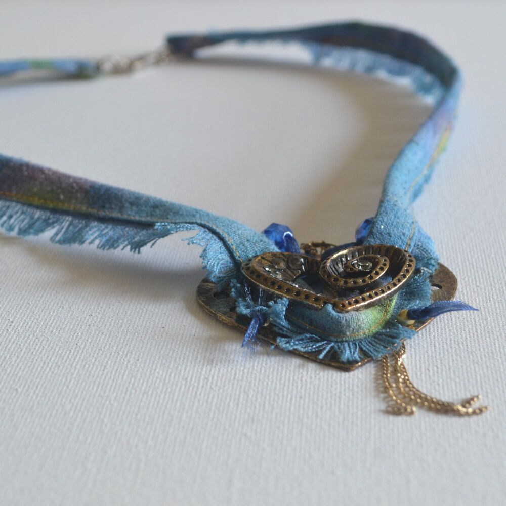 necklace detail, metal heart on blue silk
