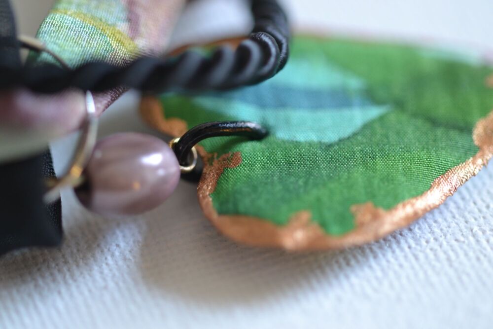 necklace detail with green silk heart and black cord
