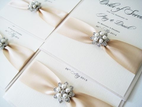 Order of service books with ribbon and brooch