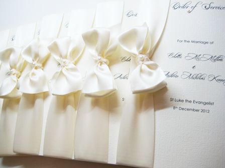 Order of service books in ivory with tied ribbon bow