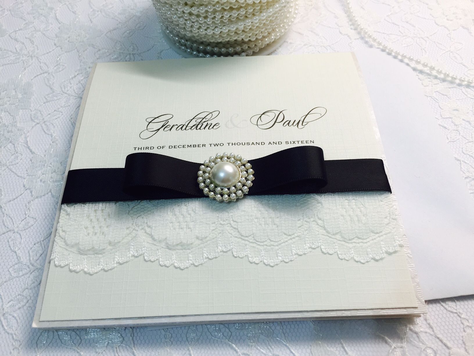 Ivory invitation with black bow and lace