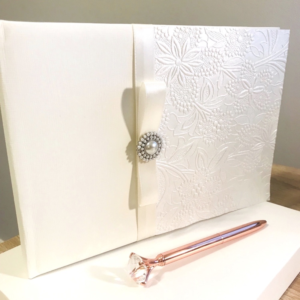 Ivory guest book with pearl brooch and ribbon