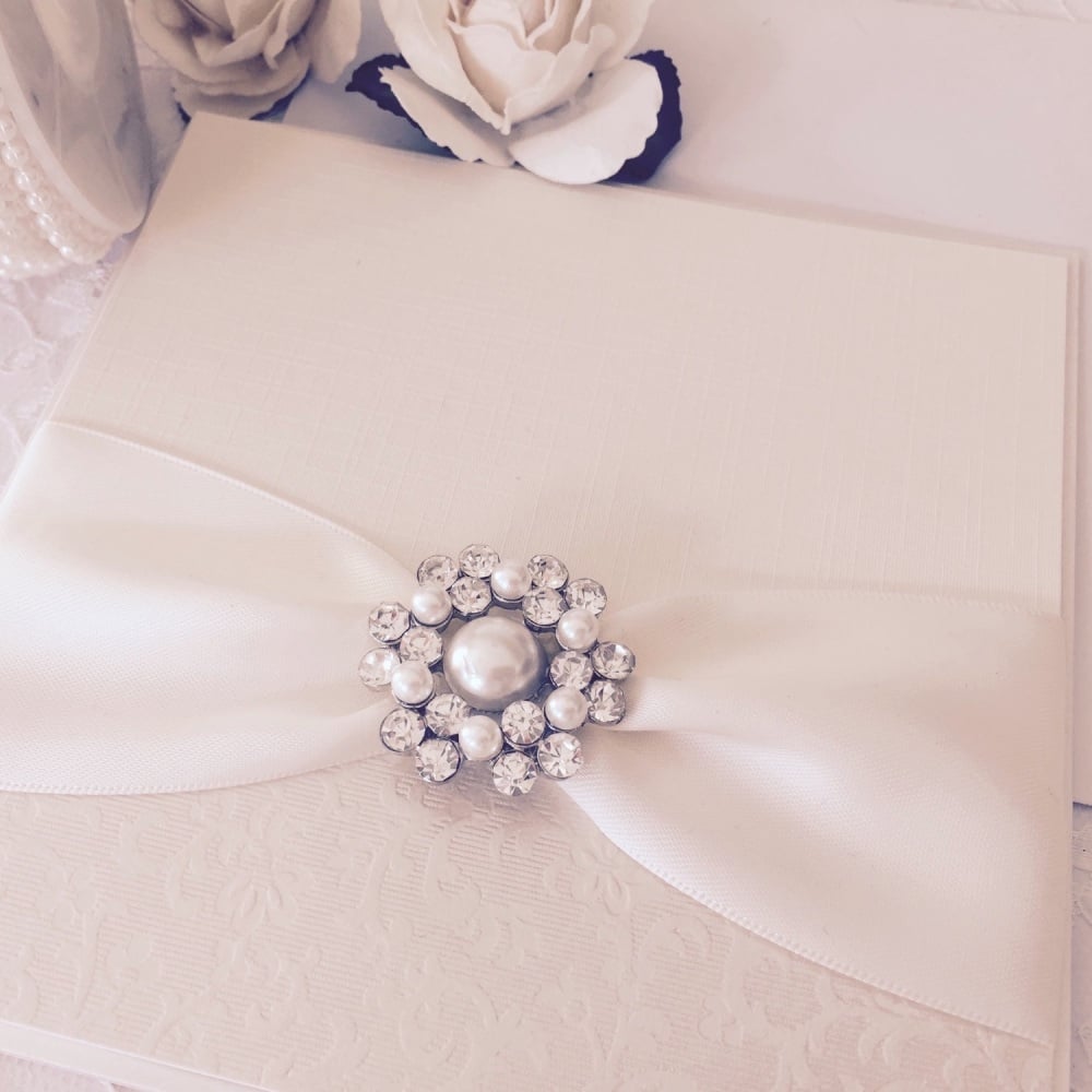 Vintage wedding invitation with pearl brooch