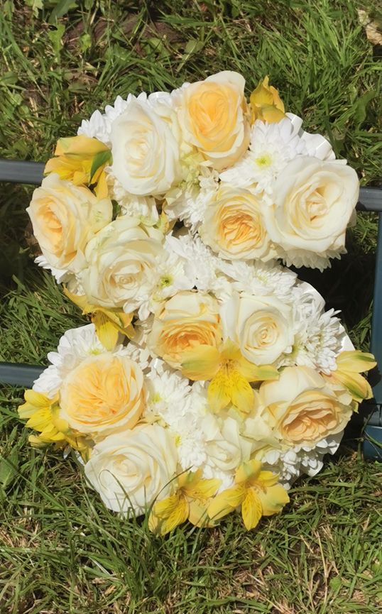 Funeral lettering with buttercup roses, white rose and alstroemeria