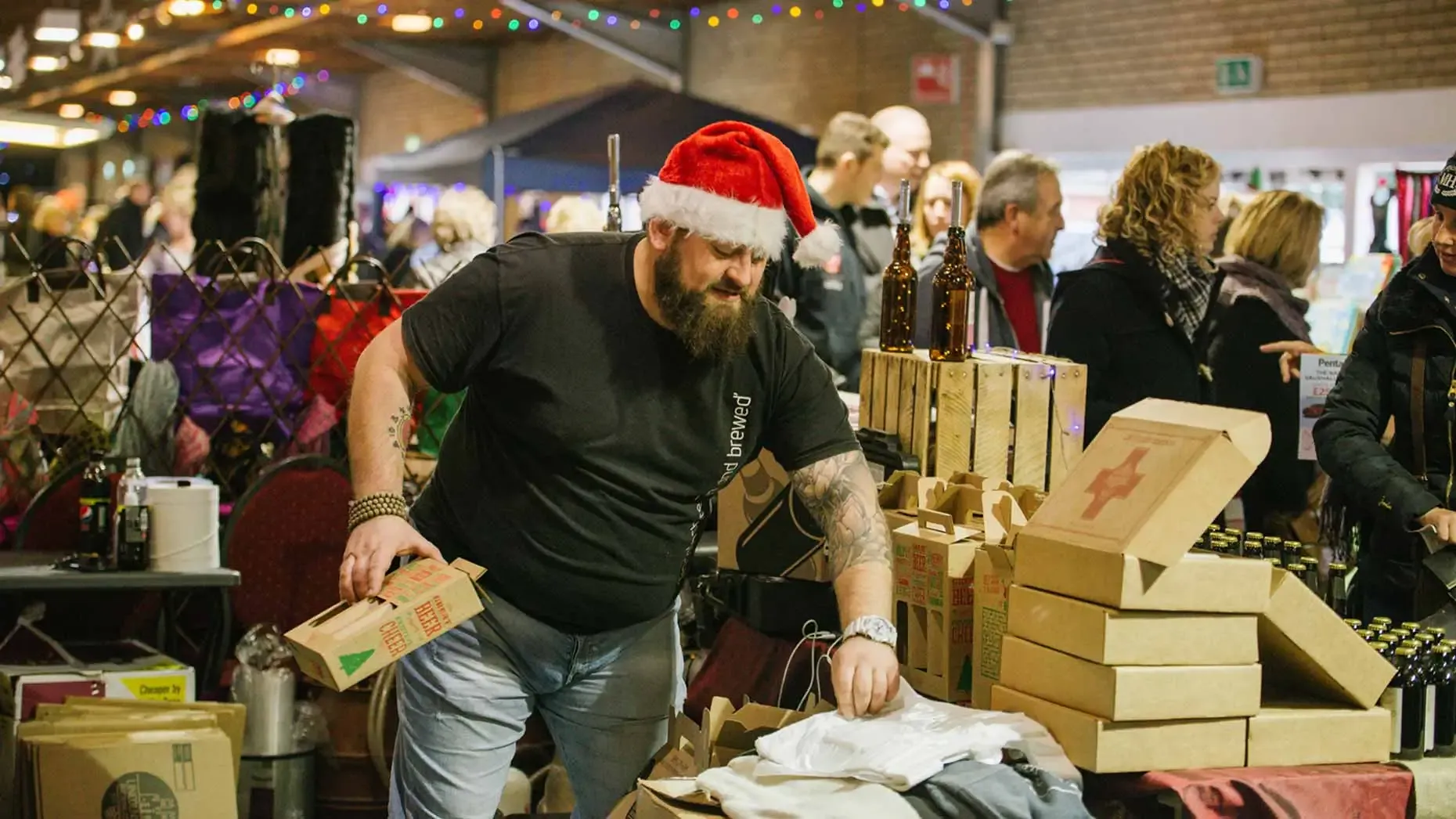 Stallholder wearing Santa hat serving visitors at the Lincolnshire Food & Gift Fair, Lincolnshire Showground