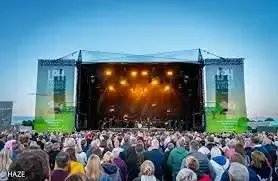 Outdoor music concert at Lincolnshire Showground with stage lighting and large audience â event cleaning services provided