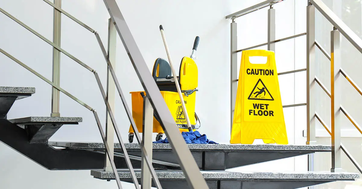 Clean communal stairwell with mop bucket and yellow caution sign after professional cleaning in Lincoln apartment building