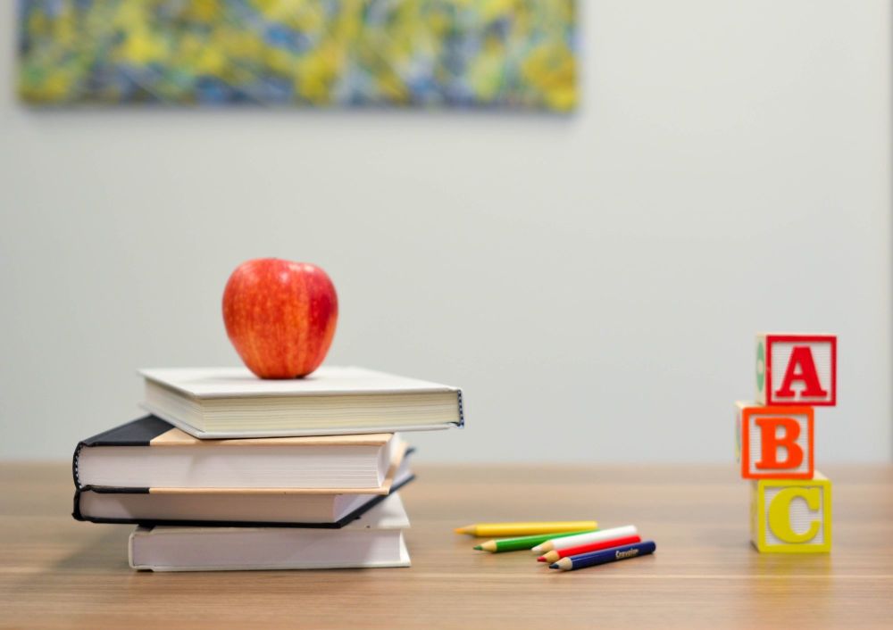 school desk with books and apple for the teacher
