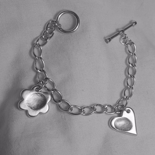 Lot - A TIFFANY & CO SILVER TAG CHARM BRACELET; 10mm wide cable link chain  to lobster claw clasp attached with a 24mm round disc charm sta...