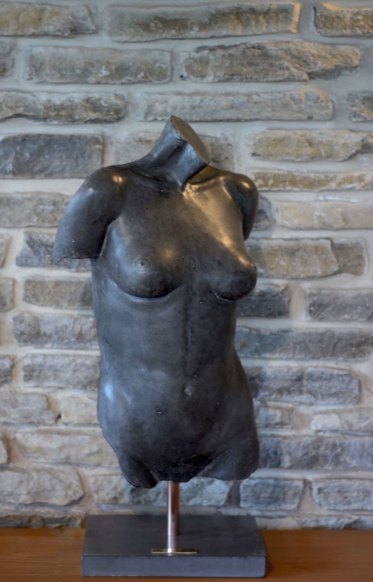 Black polished concrete female torso sculpture