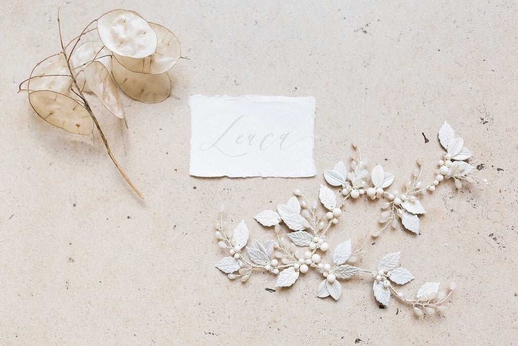 A botanical wedding headpiece made from ivory and white enamel leaves with ivory gloss pearls and white opal crystals