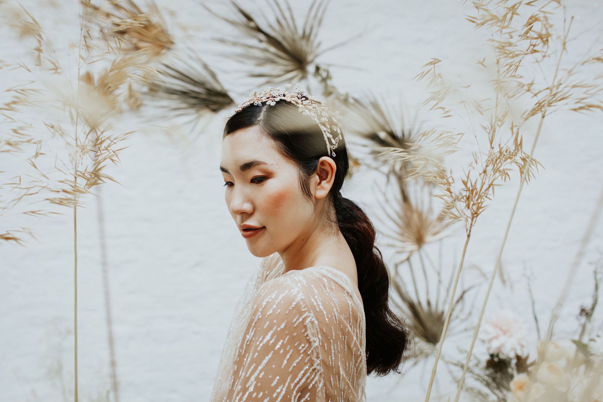 A model wears a delicate beaded bridal headdress handmade by Clare Lloyd Accessories