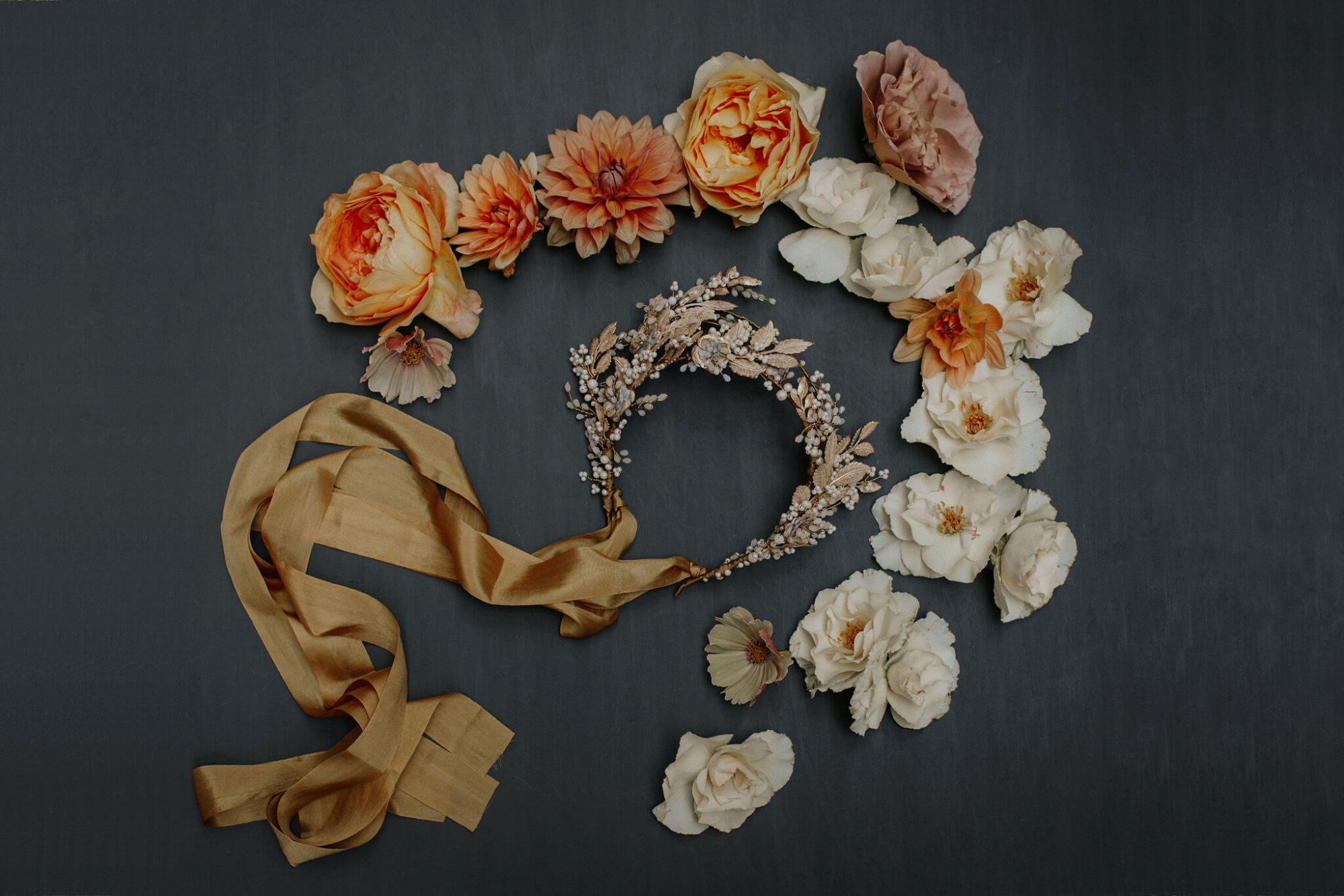 This image shows a statement gold floral bridal headdress amongst ivory and coral flowers 