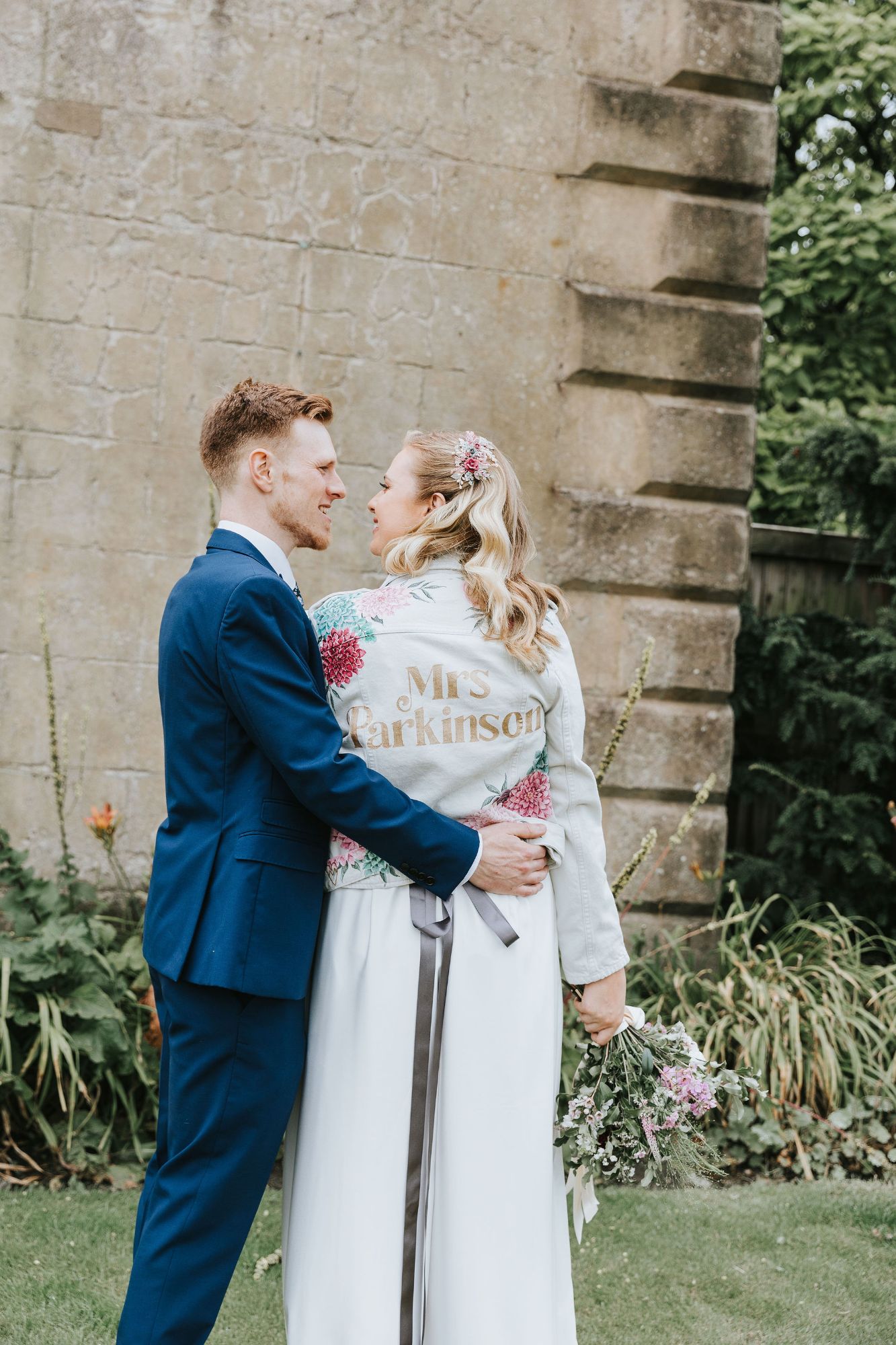 Image by Fish 2 Photography bride wears hand painted jacket and colourful floral headpiece