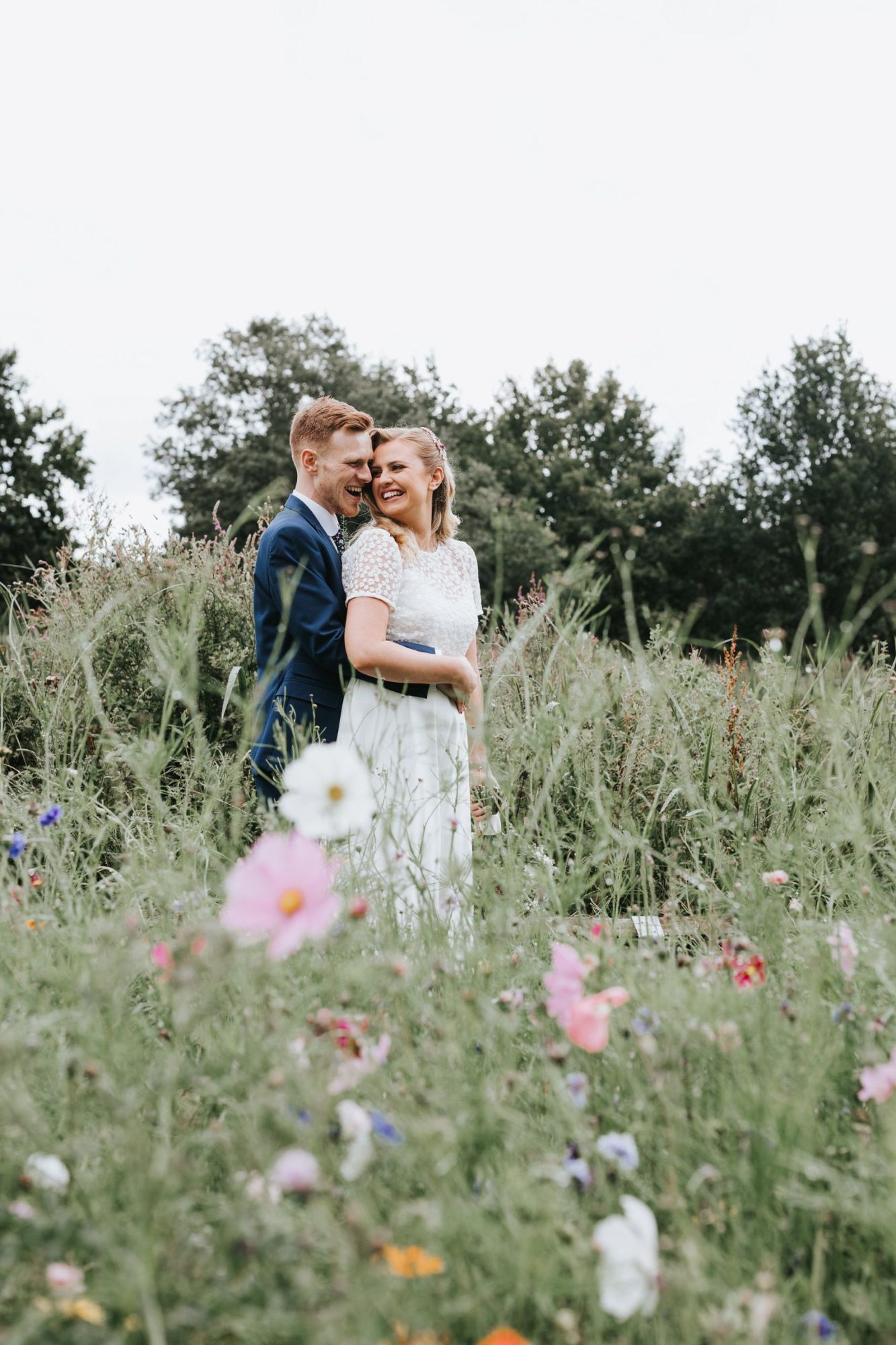 Bride and groom stand in flower meadow Fish 2 Photography
