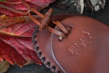 leather close up of new leather toggle and acorn leaf on a hudson bay belt