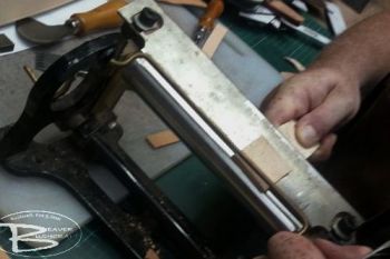 leather action shot of skiving of Mark in the workshop at beaver Bushcraft