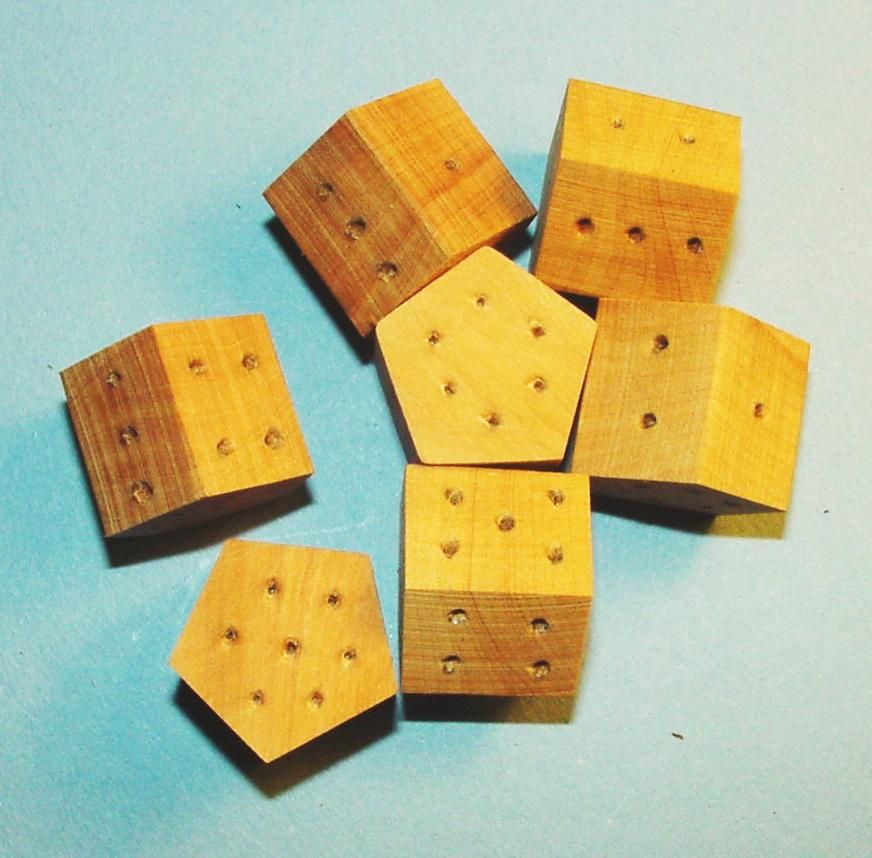 Several oak seven-sided dice from The Historic Games Shop