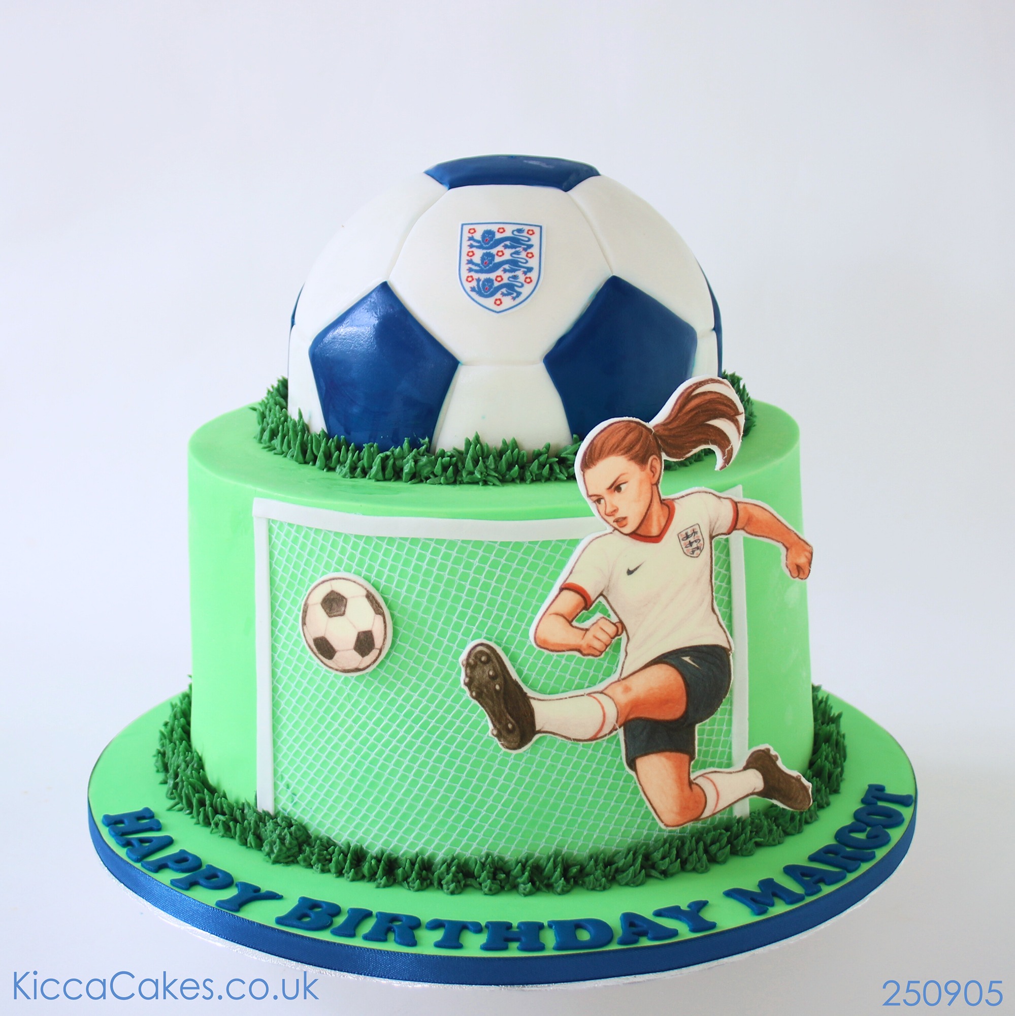 Cake in the shape of a ball with the image of a girl kicking a ball.
