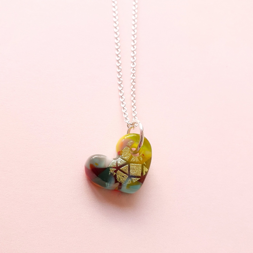 A Hand carved glass Heart on silver.