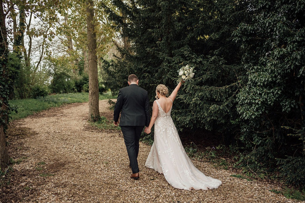Bride and groom walking in the ground of Oddhouse Farm