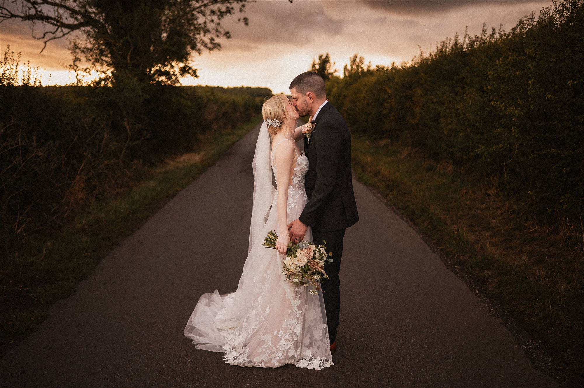 Bride and Groom hand in hand in the field at Oddhouse Farm