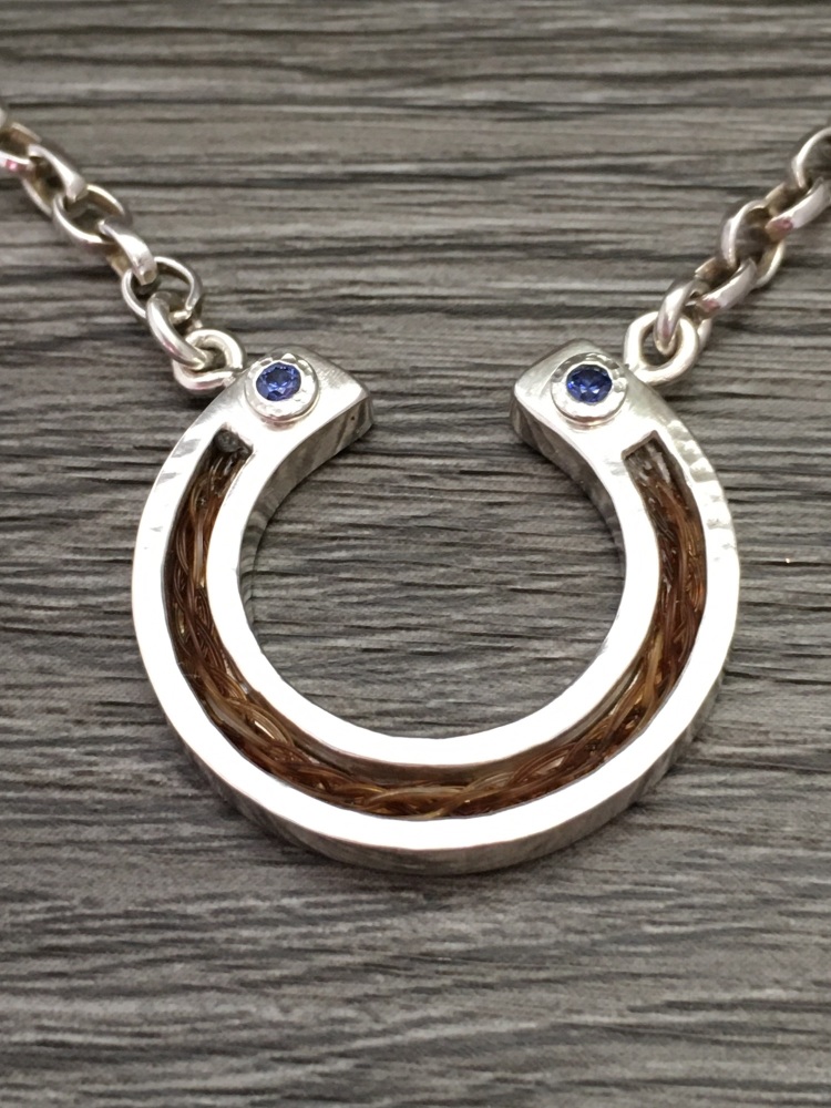 Horseshoe pendant inlaid with cubic zirconia.