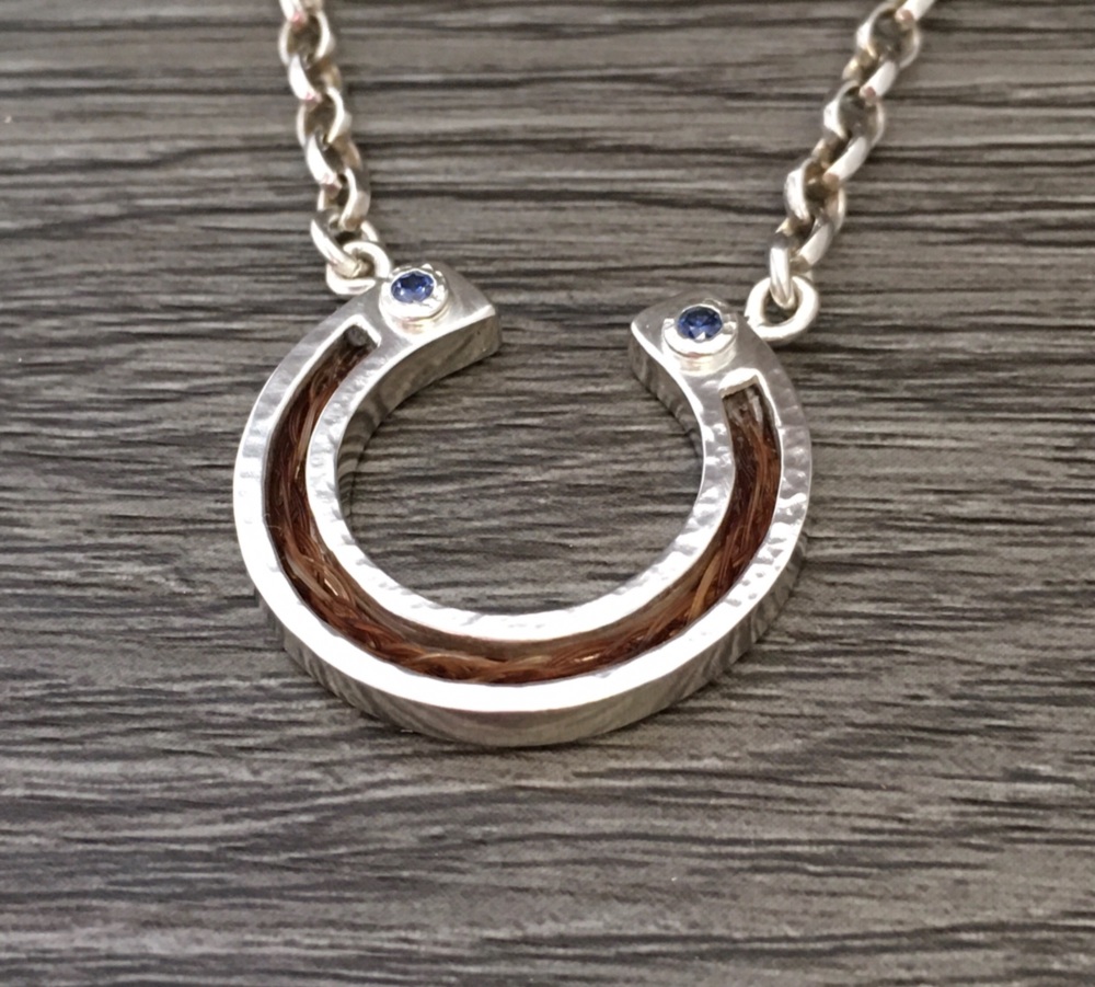 Luxury horsehair horseshoe pendant necklace with cubic zirconia.