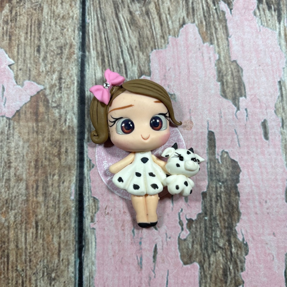 Little girl with cow print dress and baby cow with pink bow