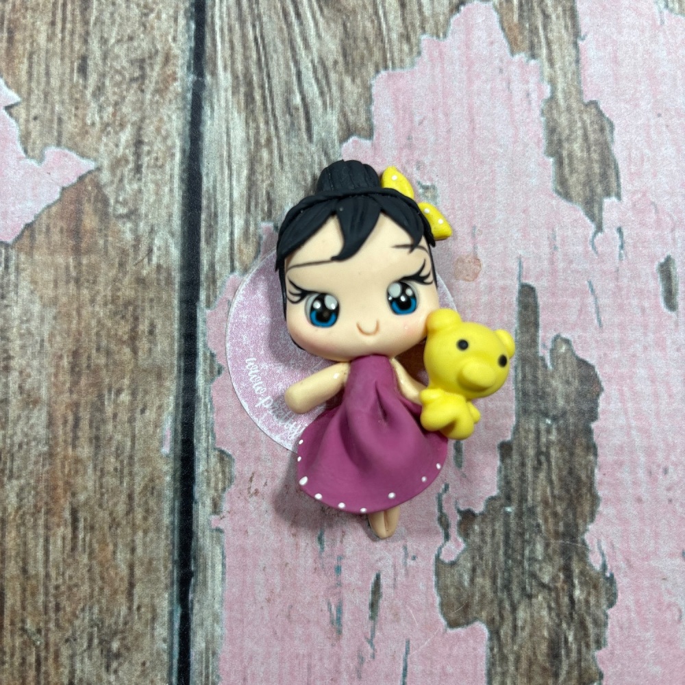 Little girl, purple dress, yellow teddy bear black hair, blue eyes