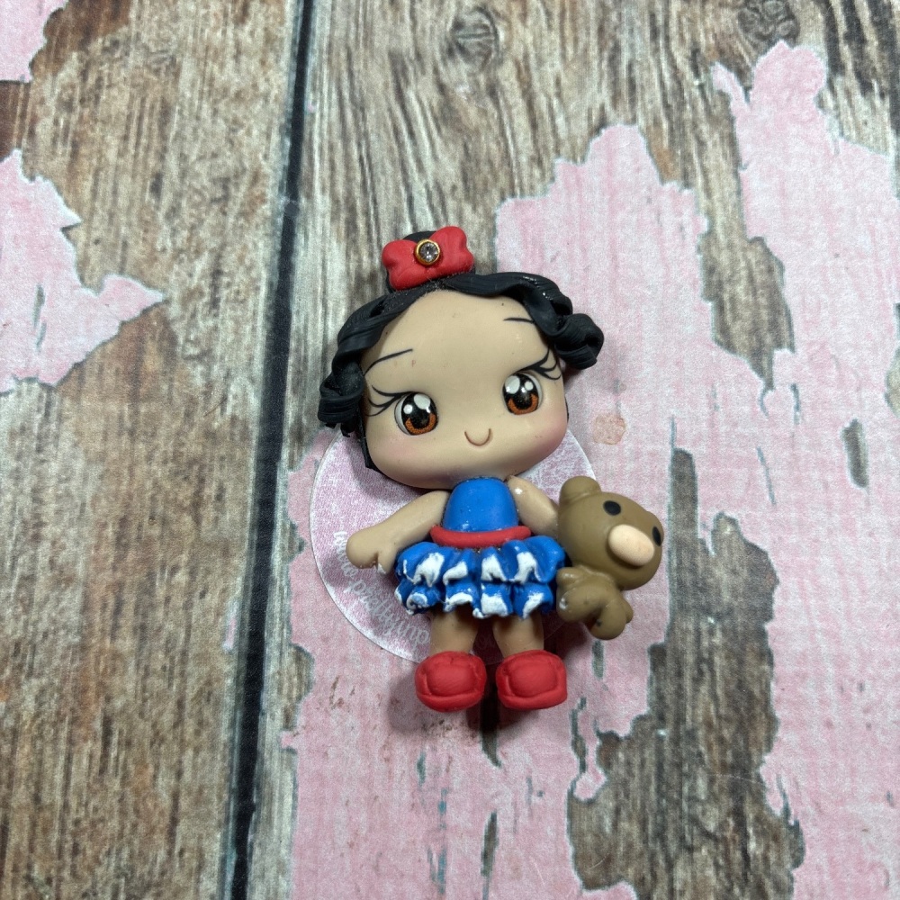 Little girl blue dress, red hair bow with teddy bear black curly hair, brown eyes