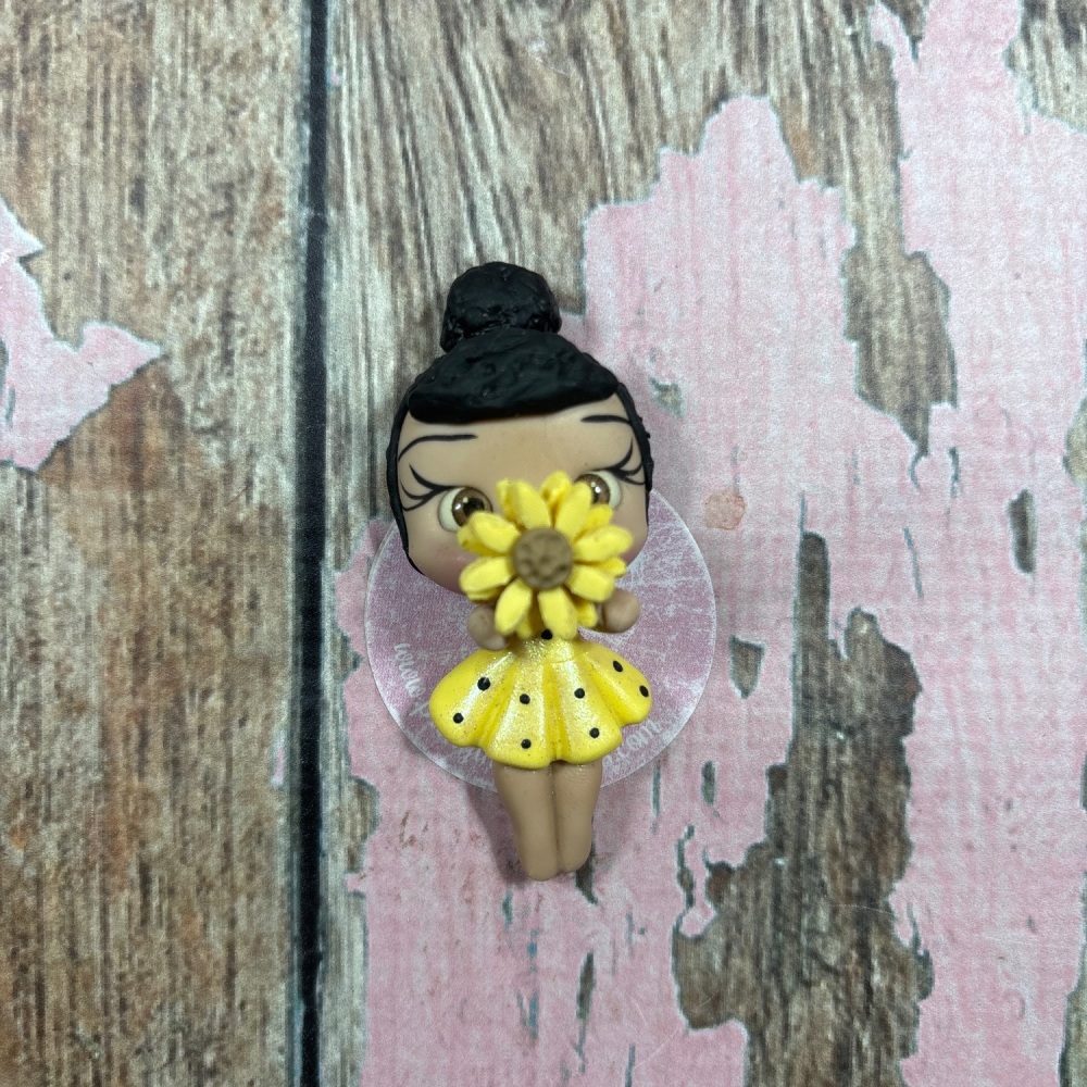 Little girl, yellow polkadot dress with sunflower black hair brown