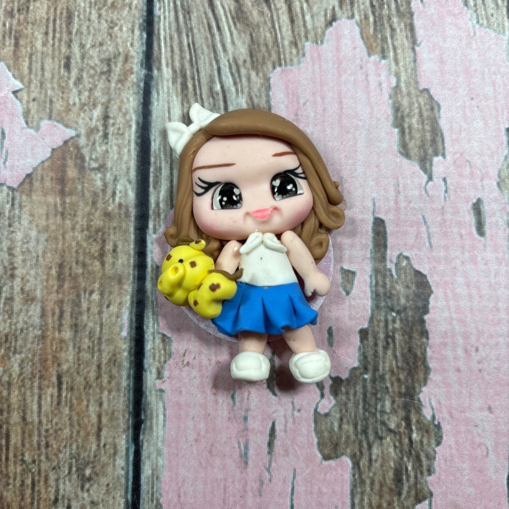 Little girl blue skirt, white top with giraffe light brown hair, grey eyes