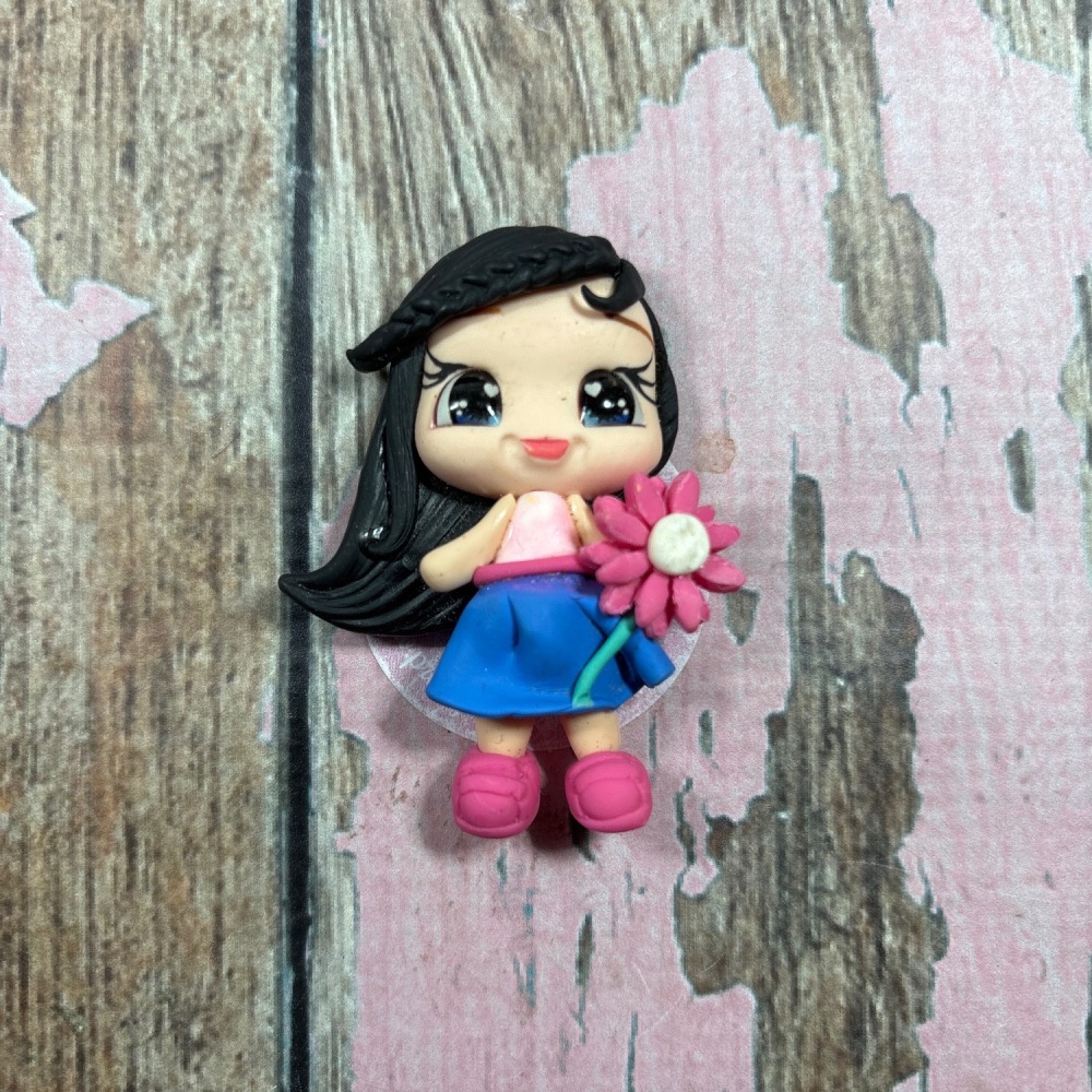 Little girl, blue skirt, pink top pink flower black hair, blue eyes
