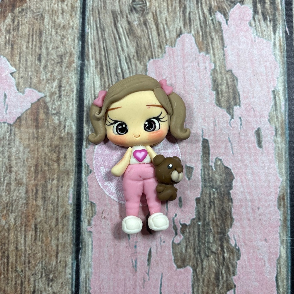 Little girl pink tracksuit bottoms, white top with teddy bear light brown hair pink Bows grey eyes