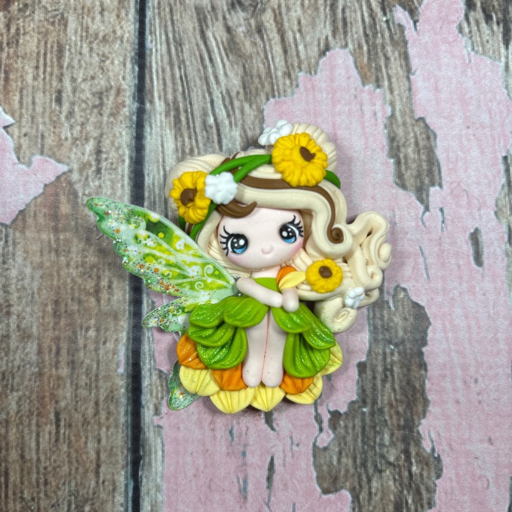 Fairy with green yellow orange dress, blonde hair with brown streaks, sunflowers in her