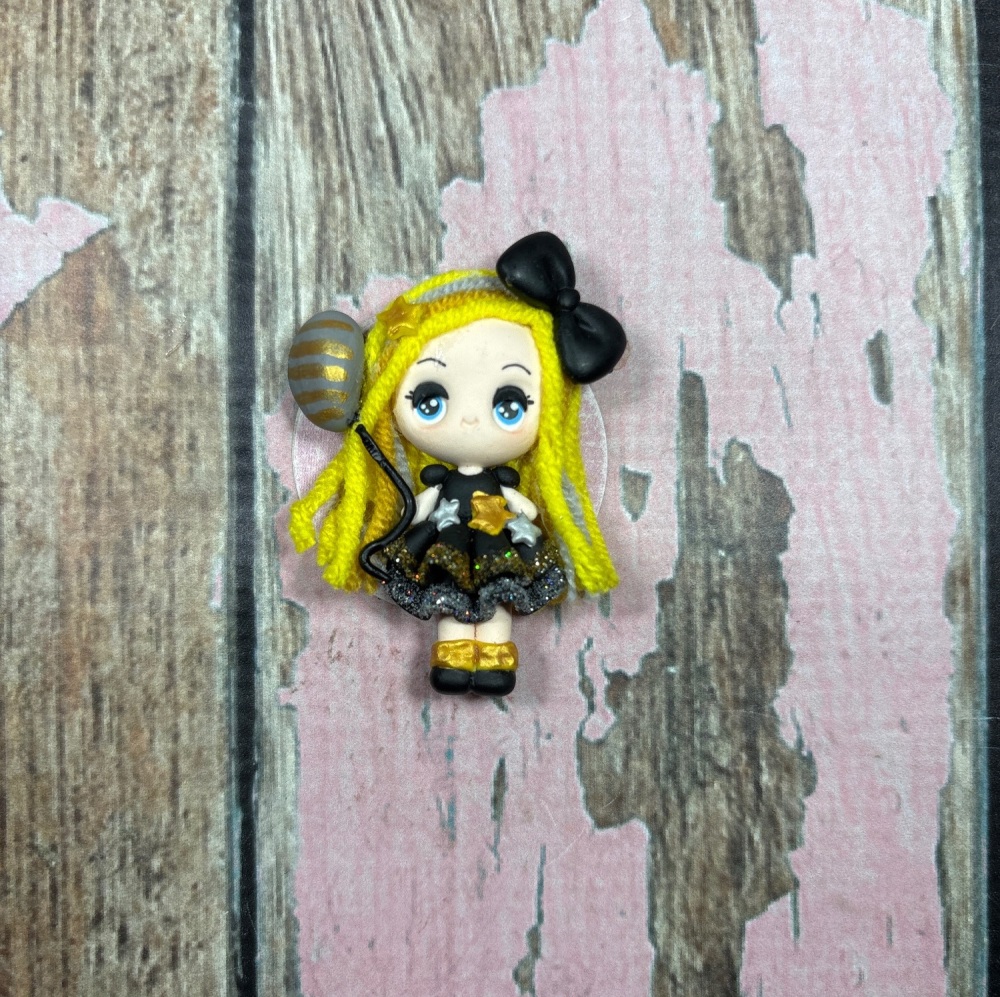 Little girl in black and gold dress with balloon