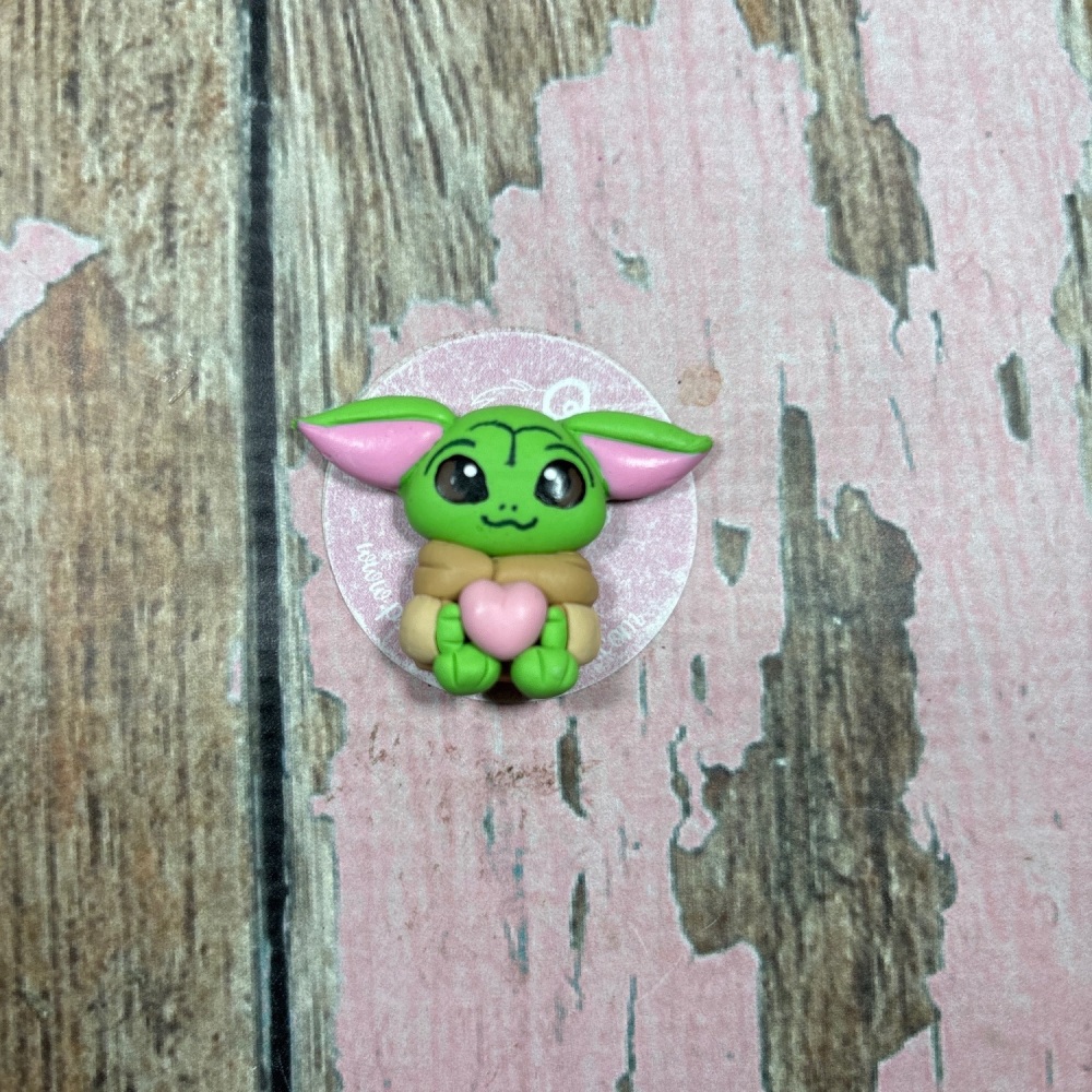 Little Baby Yoda holding a heart