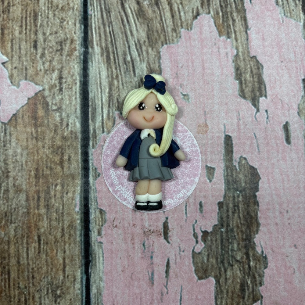 Little Girl In grey and black school uniform with blonde hair and a black bow