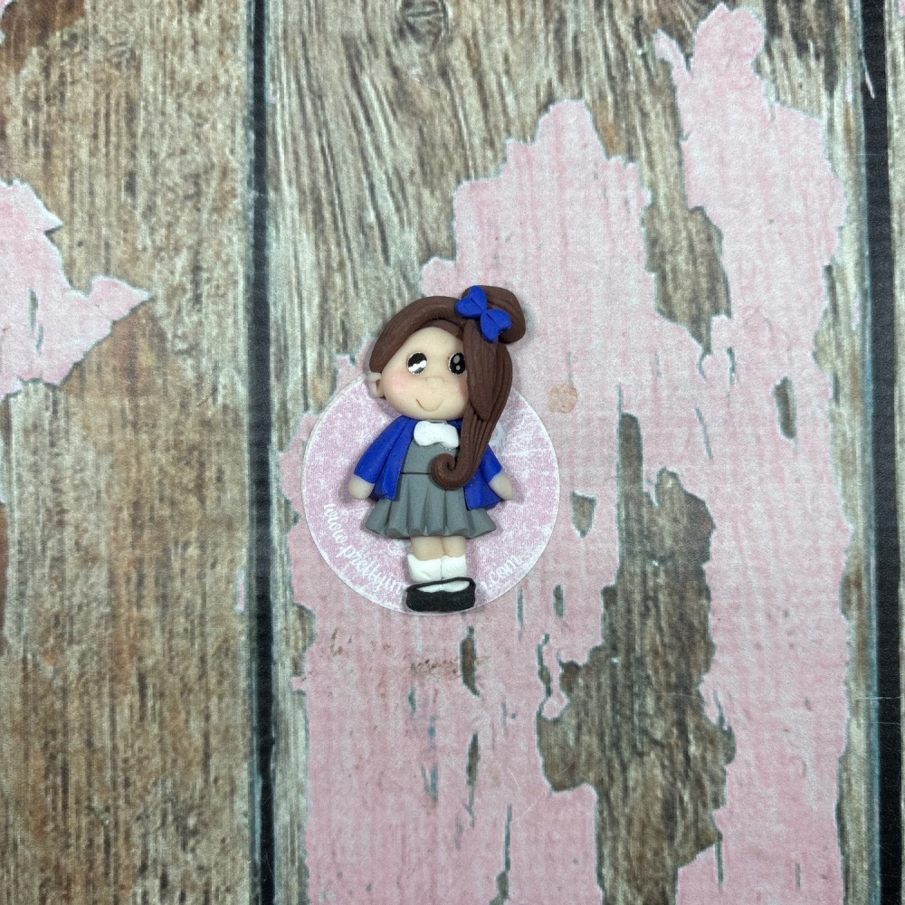 Little Girl in blue and grey school uniform with brown hair and blue bow