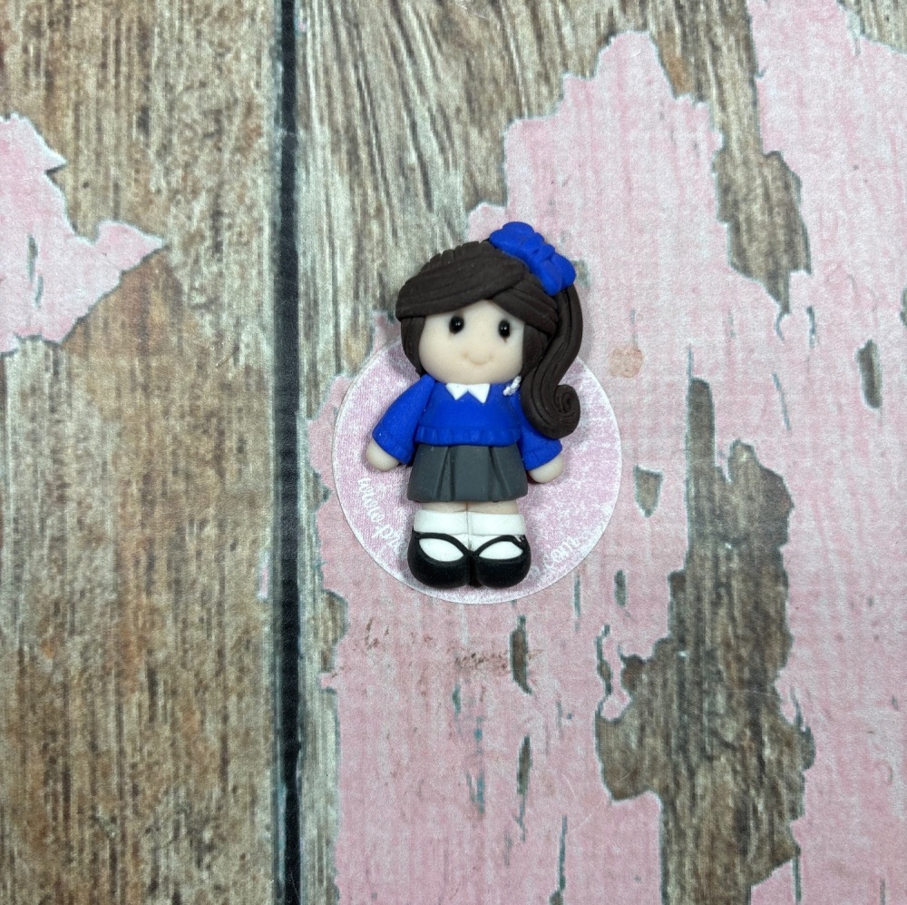 Little Girl in blue school uniform black hair and a blue bow