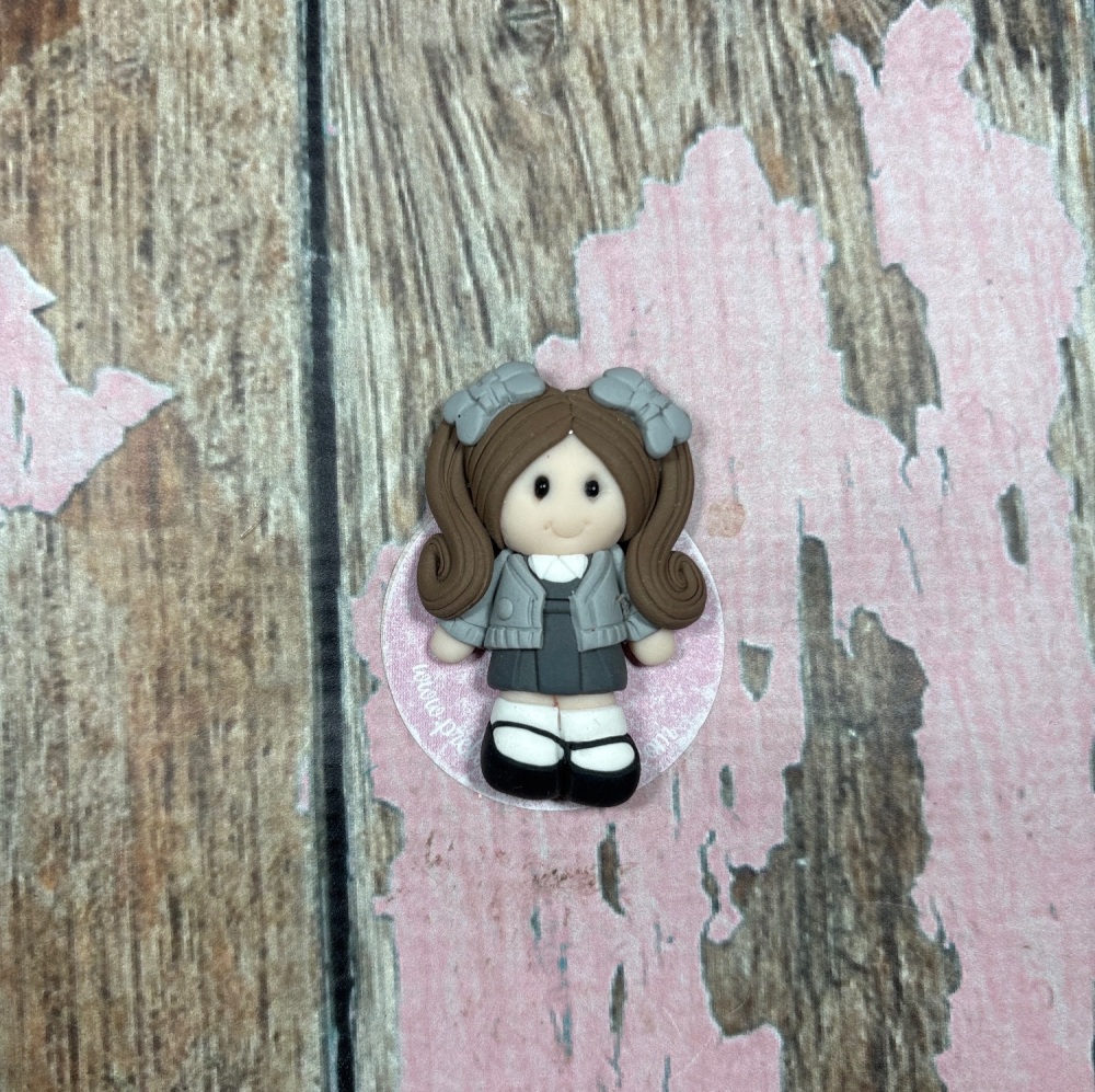 Little girl in grey school uniform brown hair and grey bows